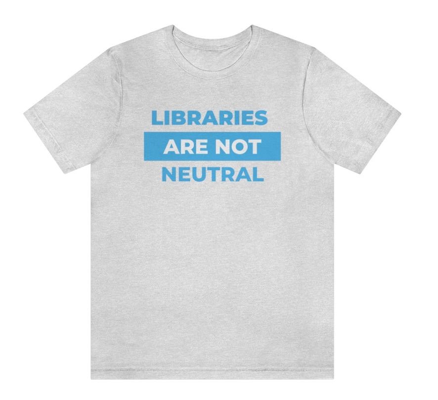 Image of a gray shirt with blue text reading "libraries are not neutral."