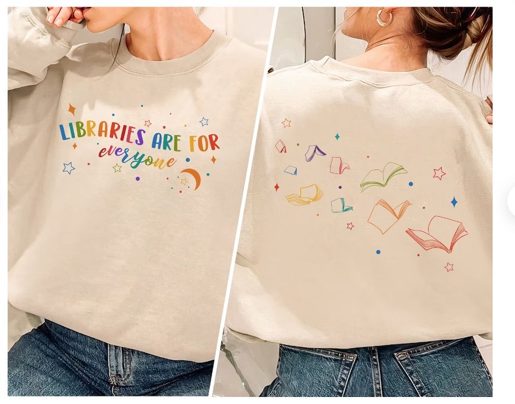 Image of a cream sweatshirt with the text "libraries are for everyone" in rainbow font. There are several rainbow colored books on the front and back. 
