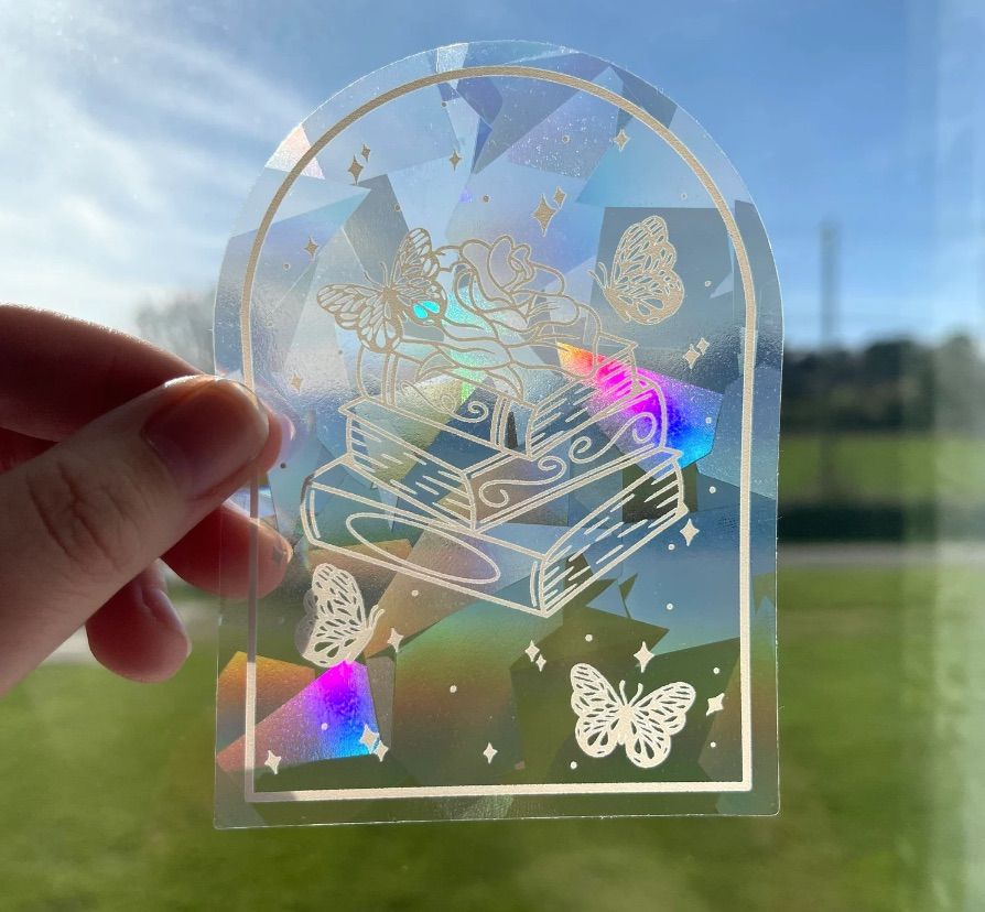 holographic sticker with books and butterflies on it. 