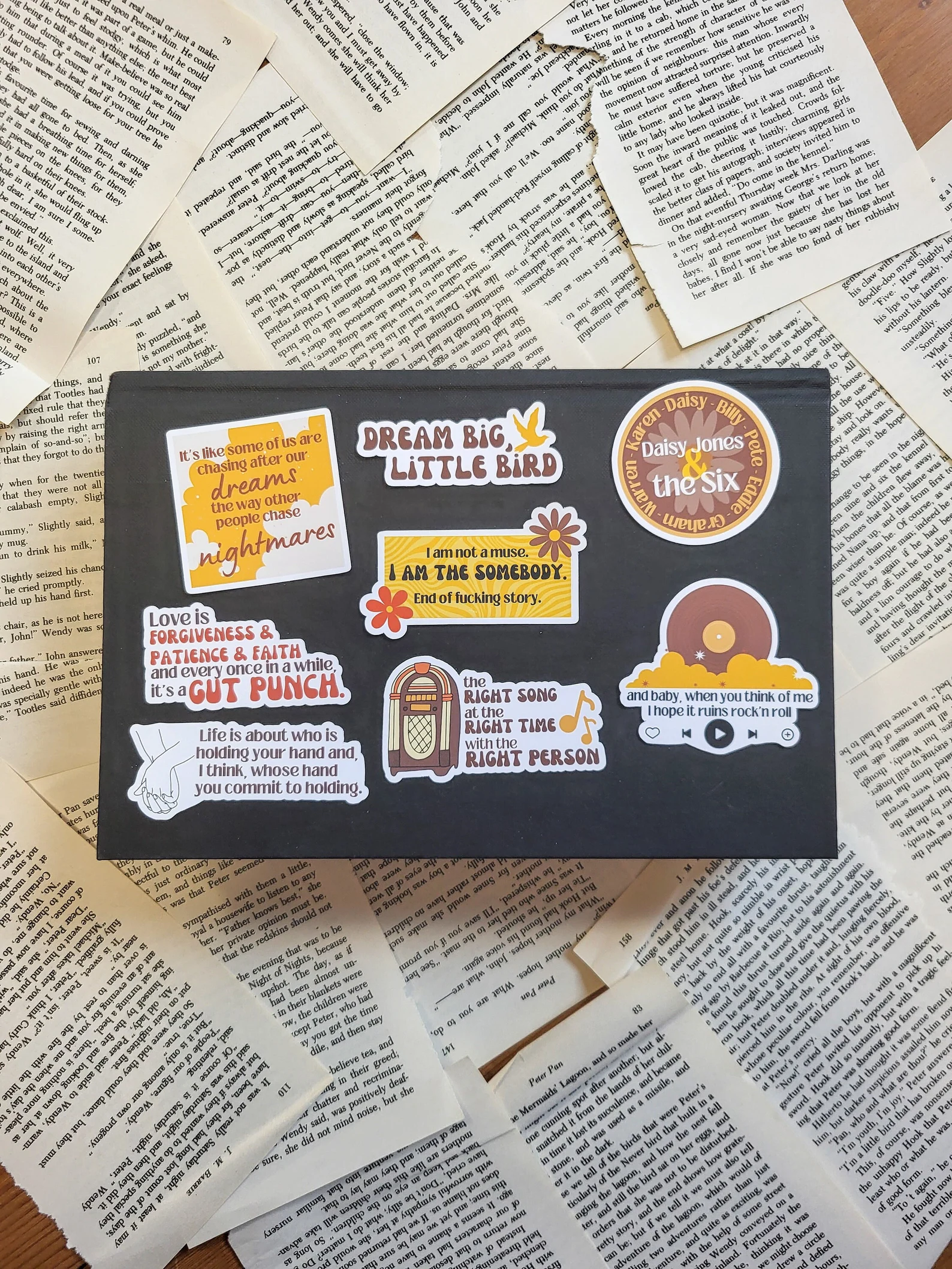 a mix of vinyl stickers in yellow and brown color tones with various quotes from the book