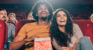 a photo of a couple laughing at a movie theater