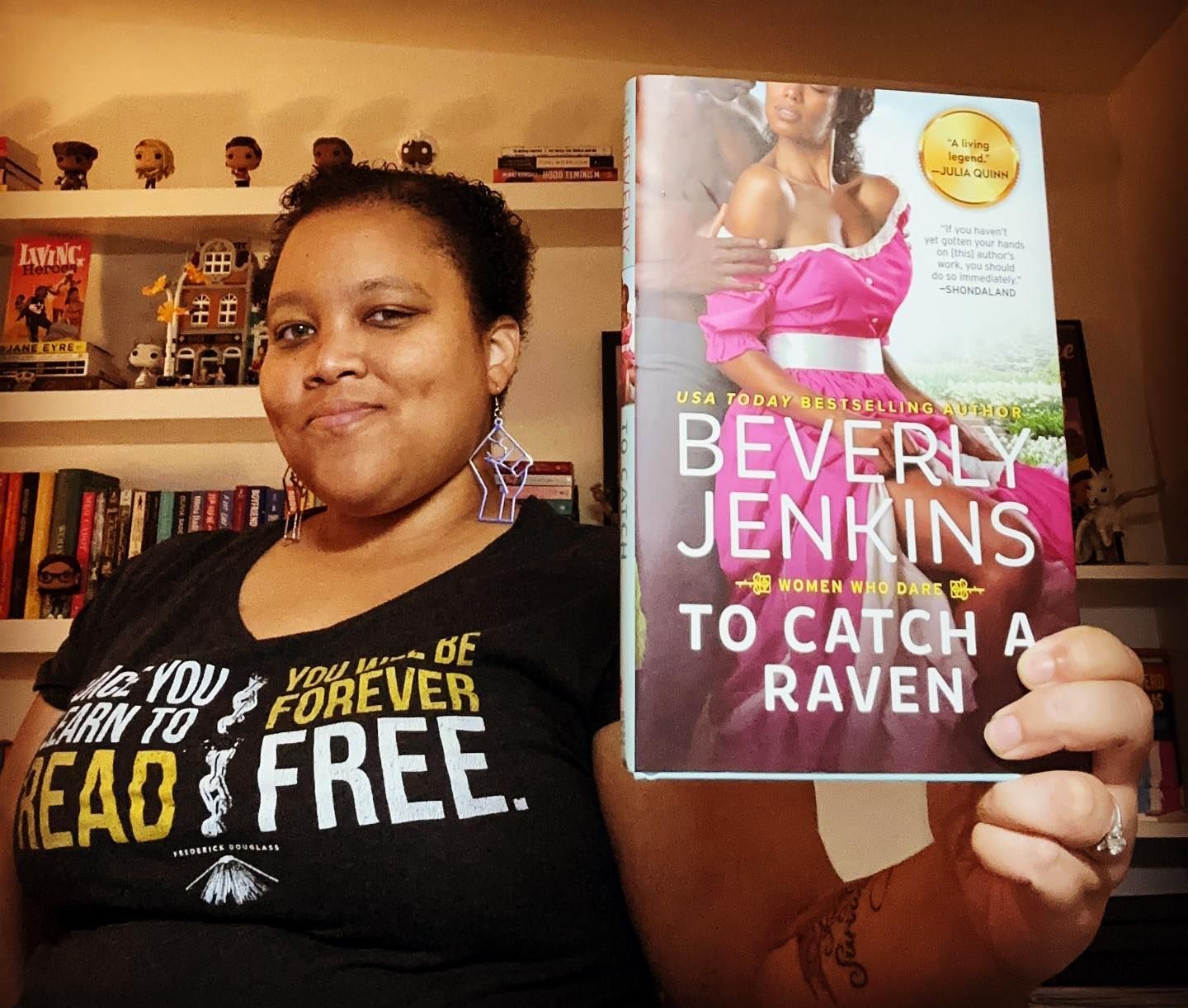 Photo of Jessica holding up a hardcover copy of Beverly Jenkins's To Catch a Raven