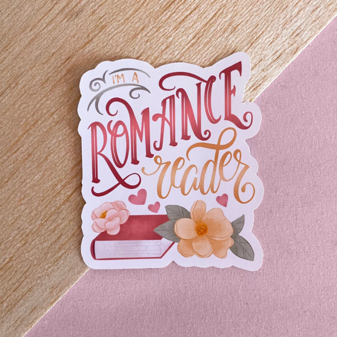 A vinyl sticker with a pink book and florals that reads "I'm a romance reader"