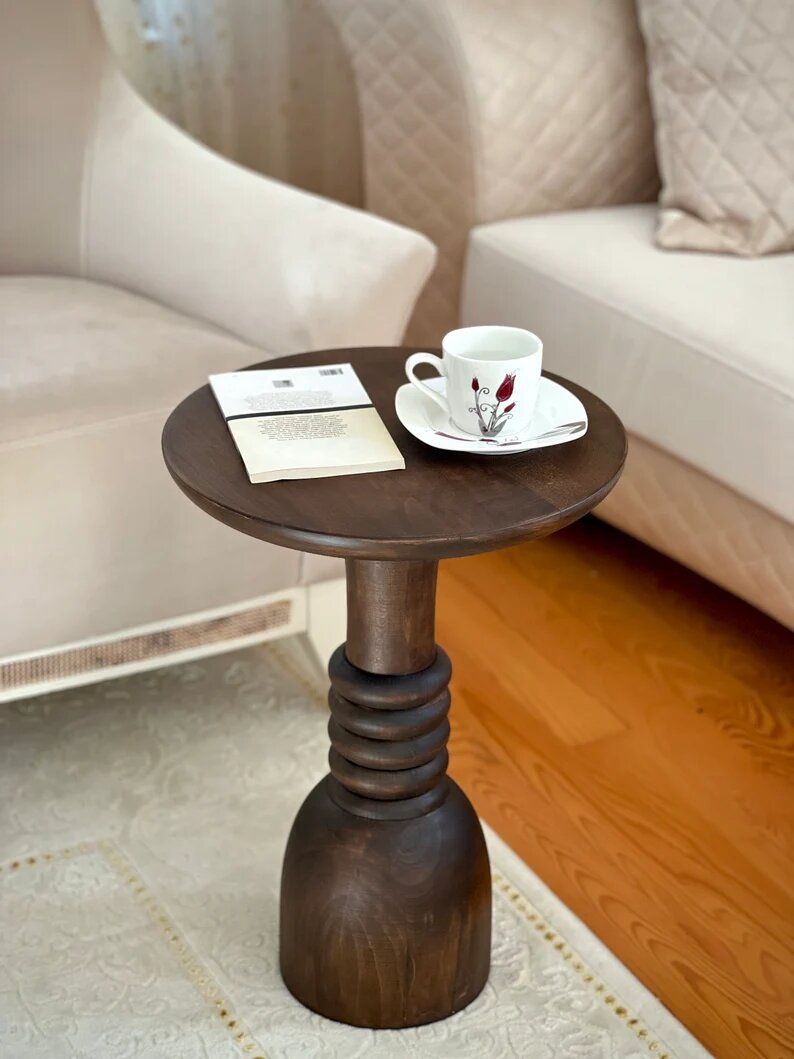 Small round table with a book and a cup on it
