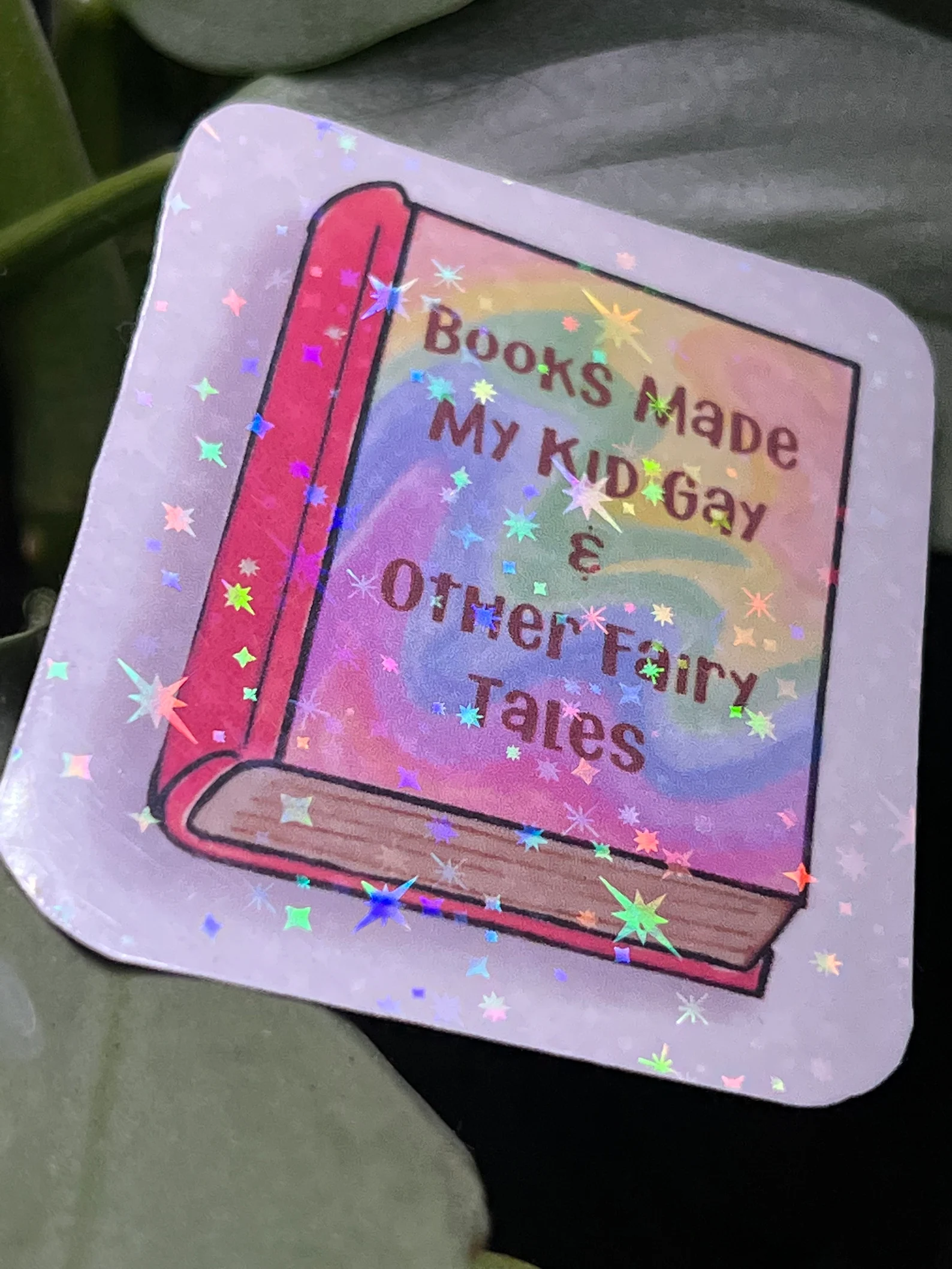 shiny sticker that says "books made me gay and other fairy tales."