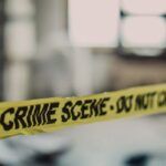 crime scene tape in front of a blurred background