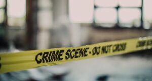 crime scene tape in front of a blurred background