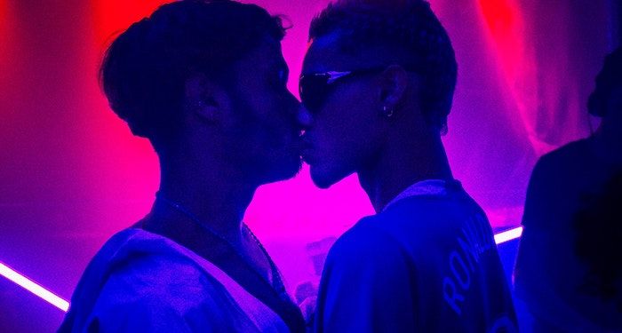 a photo of two men in a club kissing