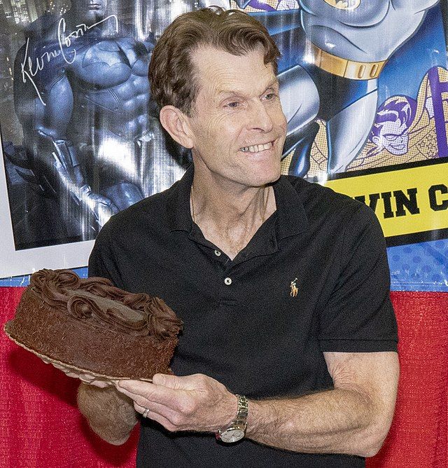 Kevin Conroy at the Louisville Supercon in 2018, holding a giant chocolate cake