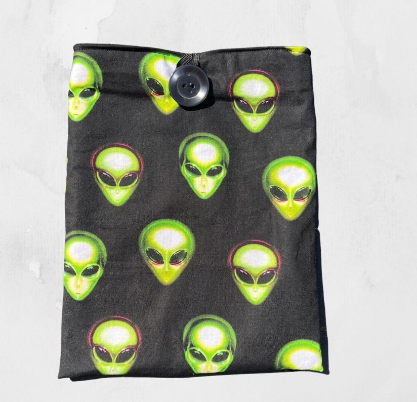 Image of a black book sleeve with green aliens.