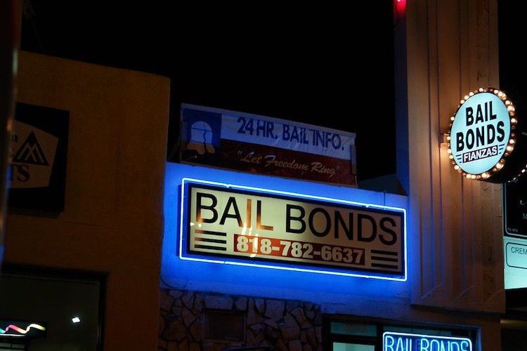 Electronic Bail Bond signs on the side of a building at night. 