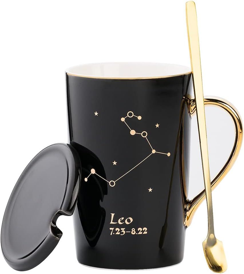 A tall black mug with gold design that says Leo and includes Leo's constellation and a gold handle, with a black ceramic lid and a long handled gold spoon
