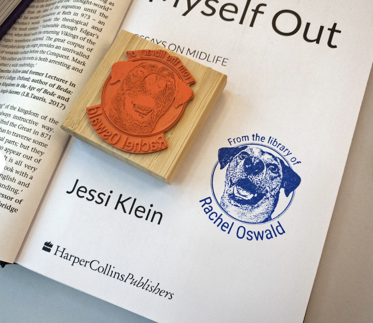 An open book showing a rubber stamp with a dog's face and the text "From the Library of Rachel Oswald"along with a print from the stamp in blue ink.