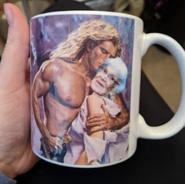 a mug with a romance cover on it with a shirtless white  male model hugging a white woman and the face of the woman can be customized 