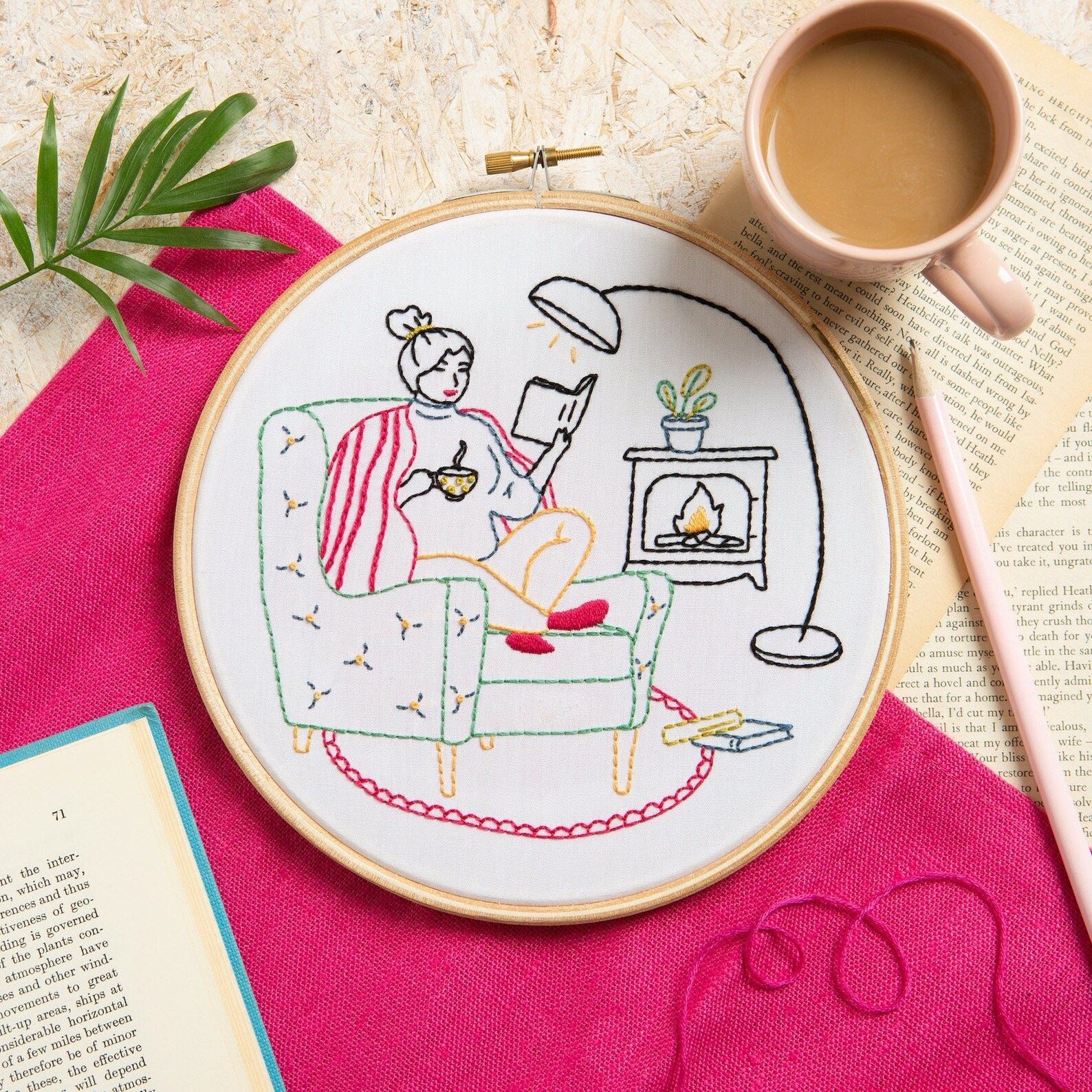 embroidery of a girl reading a book by a fire