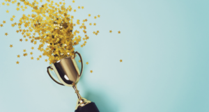 a gold trophy with gold star confetti spilling from it