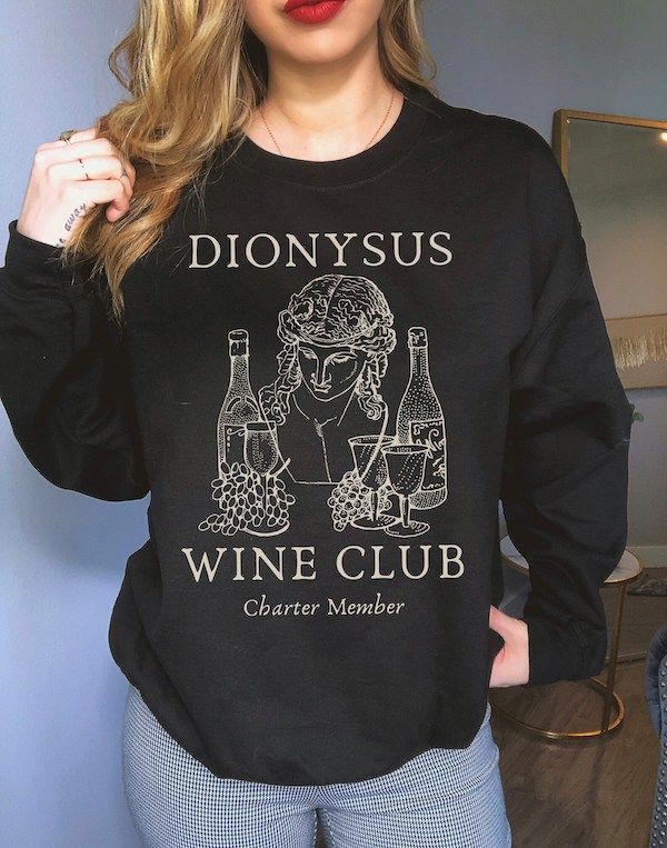 black sweatshirt with the words "Dionysus Wine Club" plus line drawings of Dionysus, wine bottles, goblets, and grapes