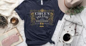 heather navy blue tshirt with text that reads "Circe's Island Bar & Restaurant. Ethically Sourced. Fine Wines, Pork Rinds"