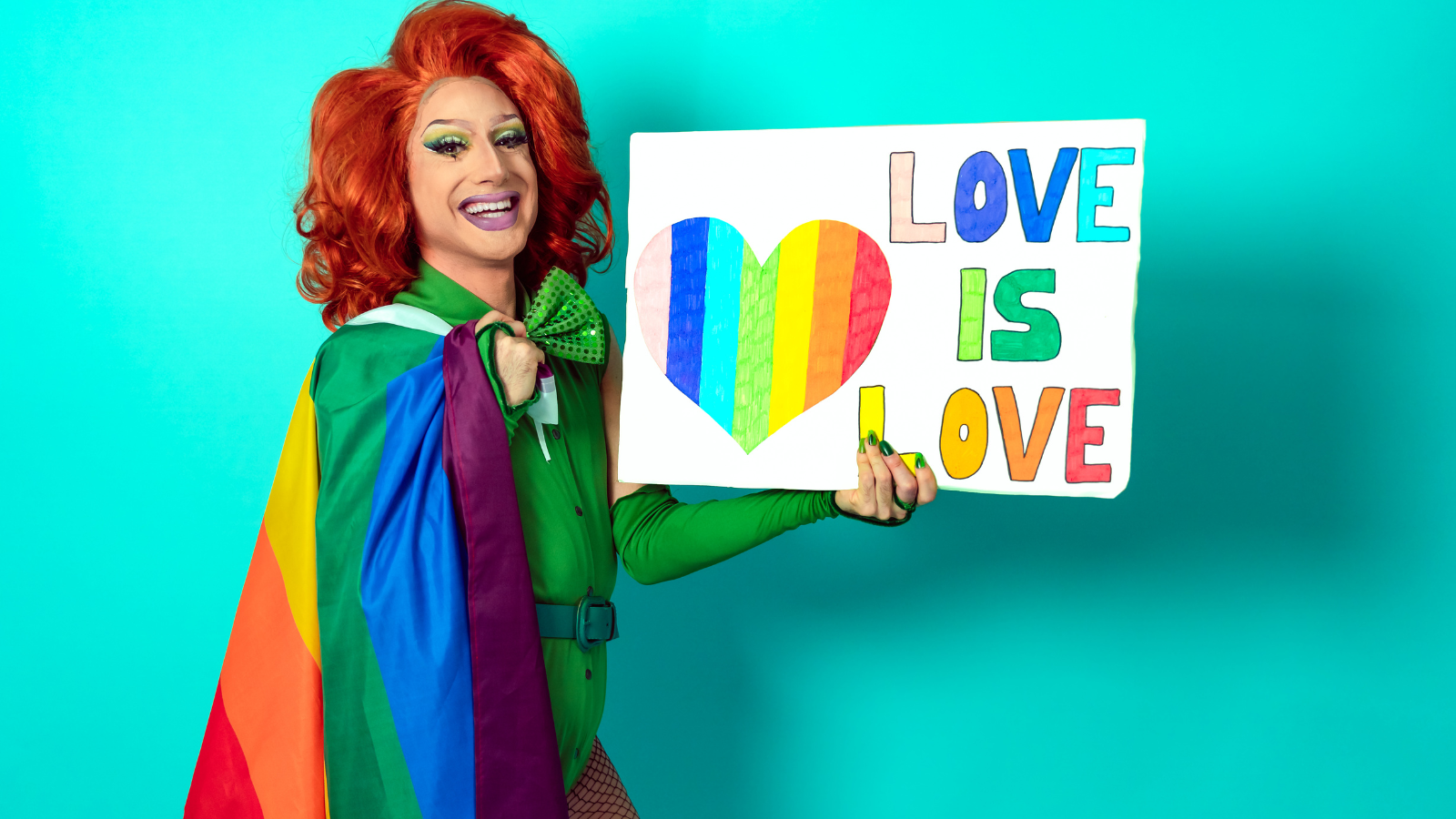 image of a drag queen holding a sign saying "love is love."