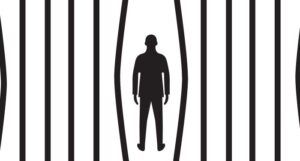Image of a person standing between bent prison bars