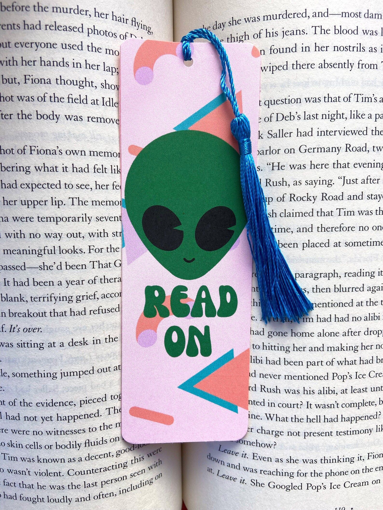 Image of a pink bookmark with a green alien. Text says "read on."