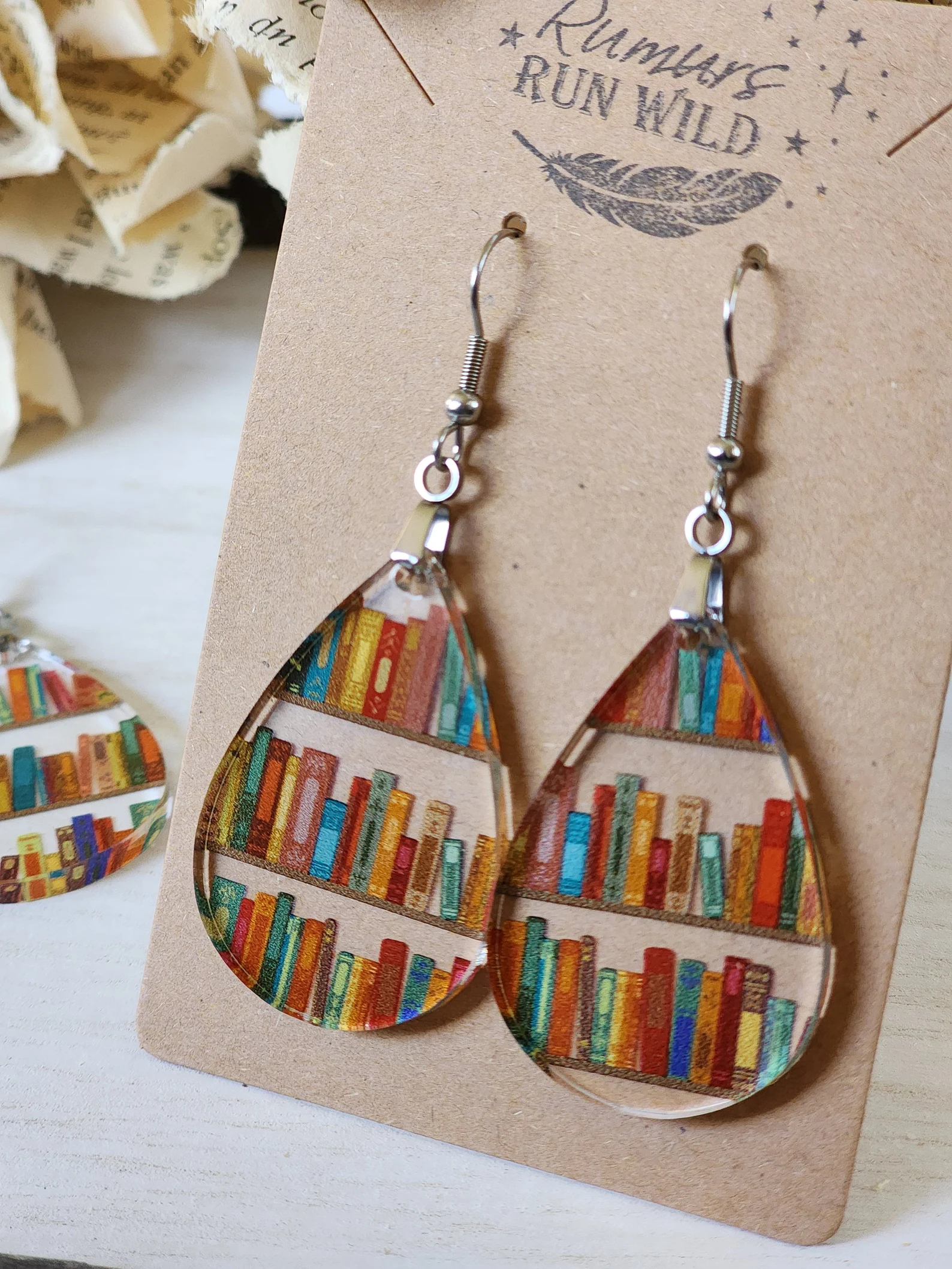 Small teardrop-shaped earrings with a design of colorful bookshelves.