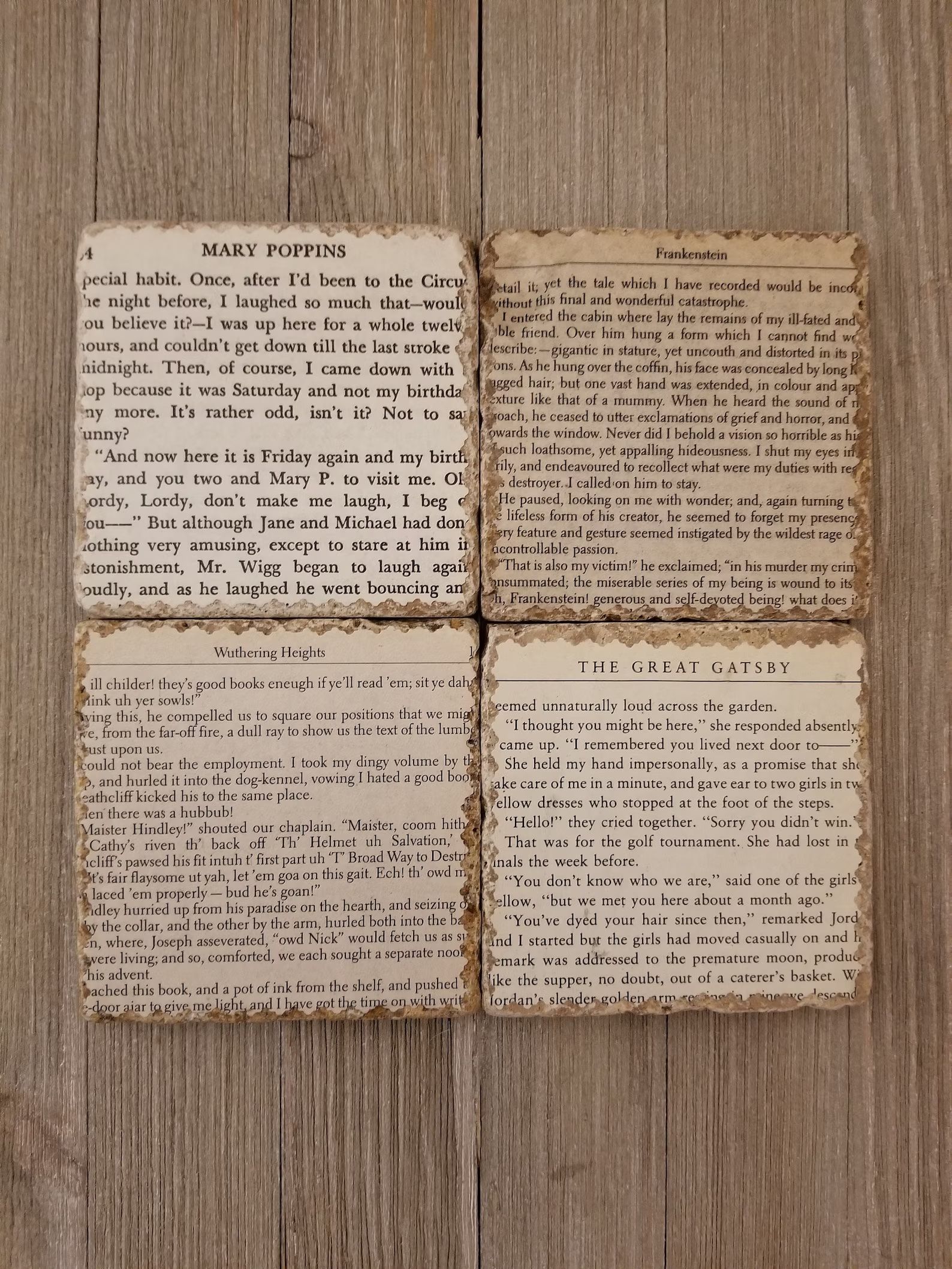 Four coasters with pages from books printed on them are on a wooden table.