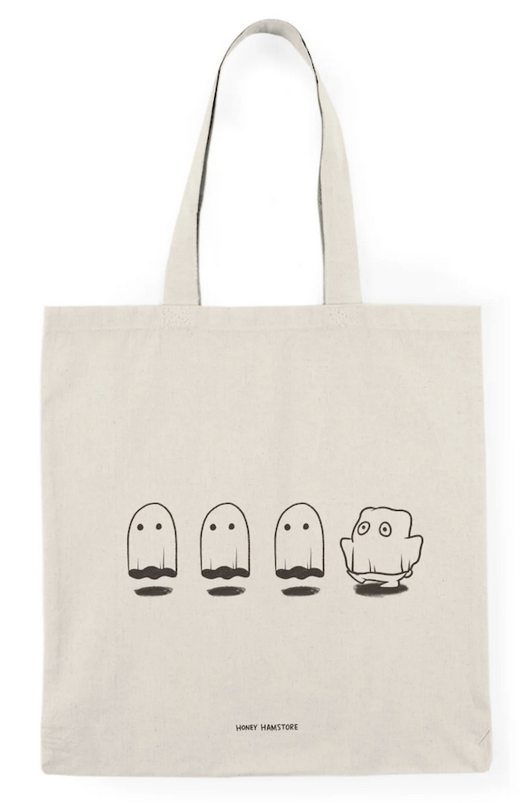 being tote bag with a screen printed design of three ghosts floating and a child in a sheet trying to immitate