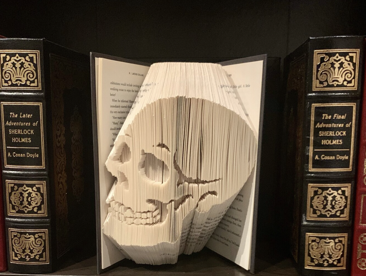 A book with pages folded to create a smiling skull shape