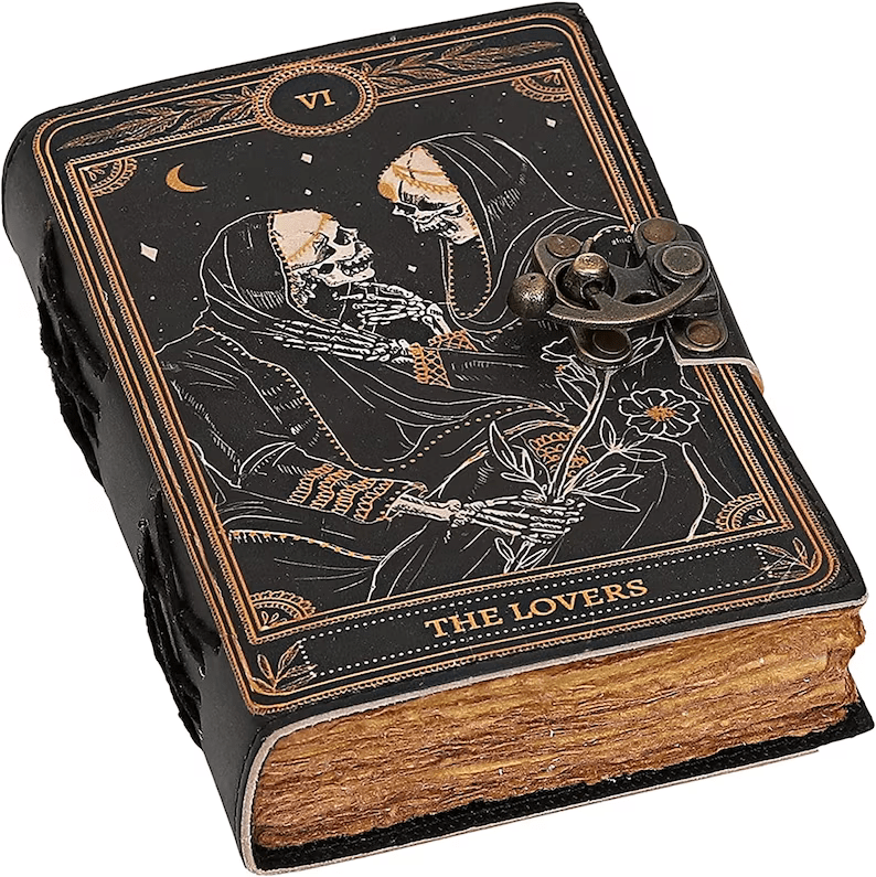 Photo of a leather-bound journal showing two skeletons half embracing each other representing the VI tarot card, the lovers