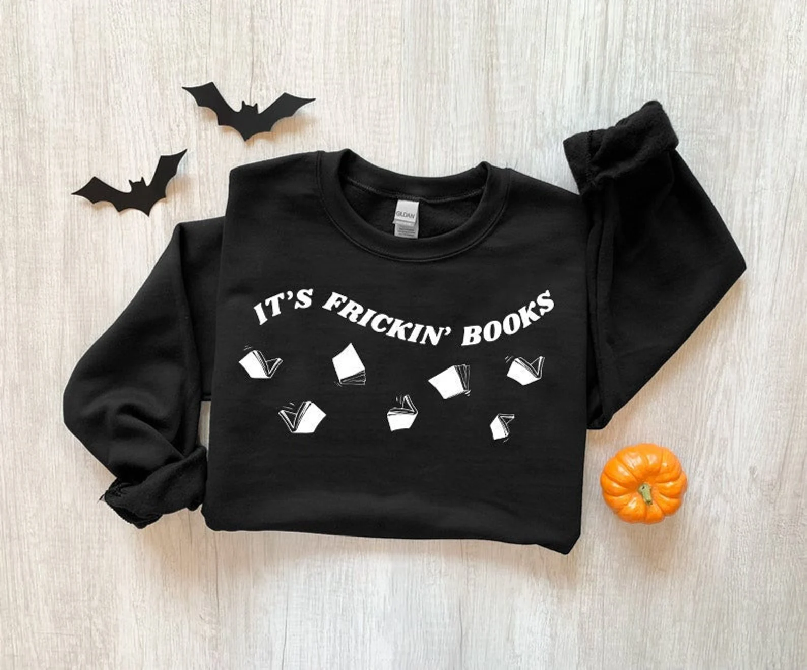 Black sweatshirt with books shaped like bats. Text reads "it's frickin' books."