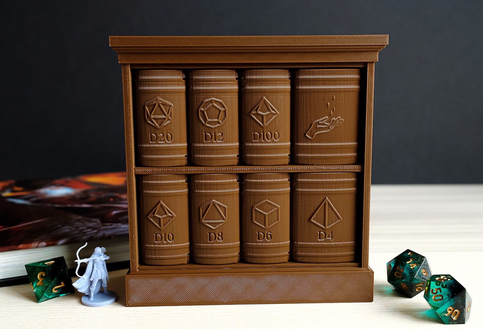 container with 8 book-shaped drawers is on a table with a mini figure and dice.
