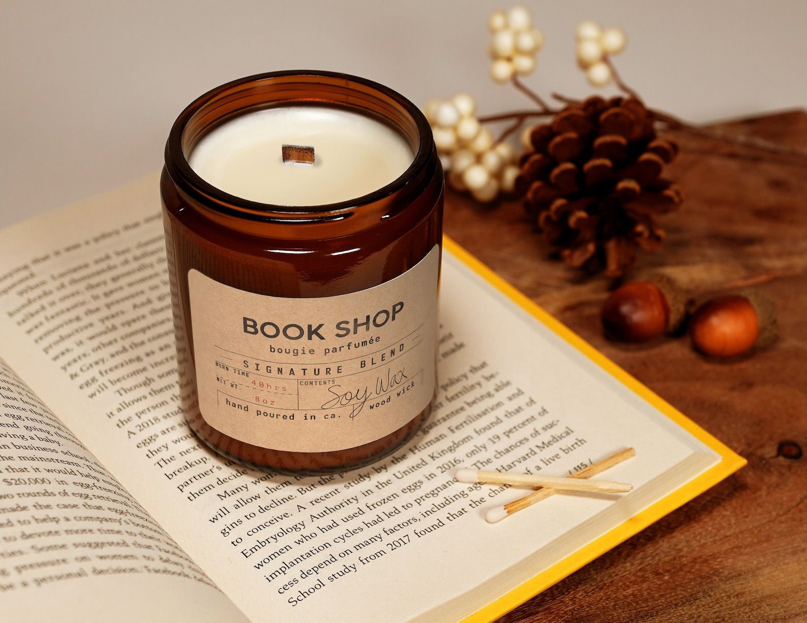 a photo of a candle in a glass jar labeled Book Shop sitting on a book