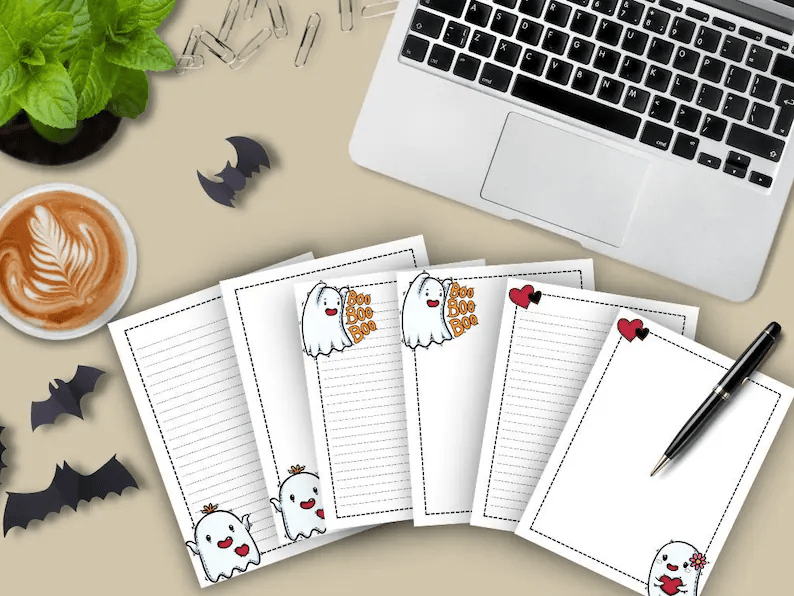 Photo of notepad sheets to print with ghosts on the margins, one with the words Boo Boo Boo next to it and the others holding hearts. 