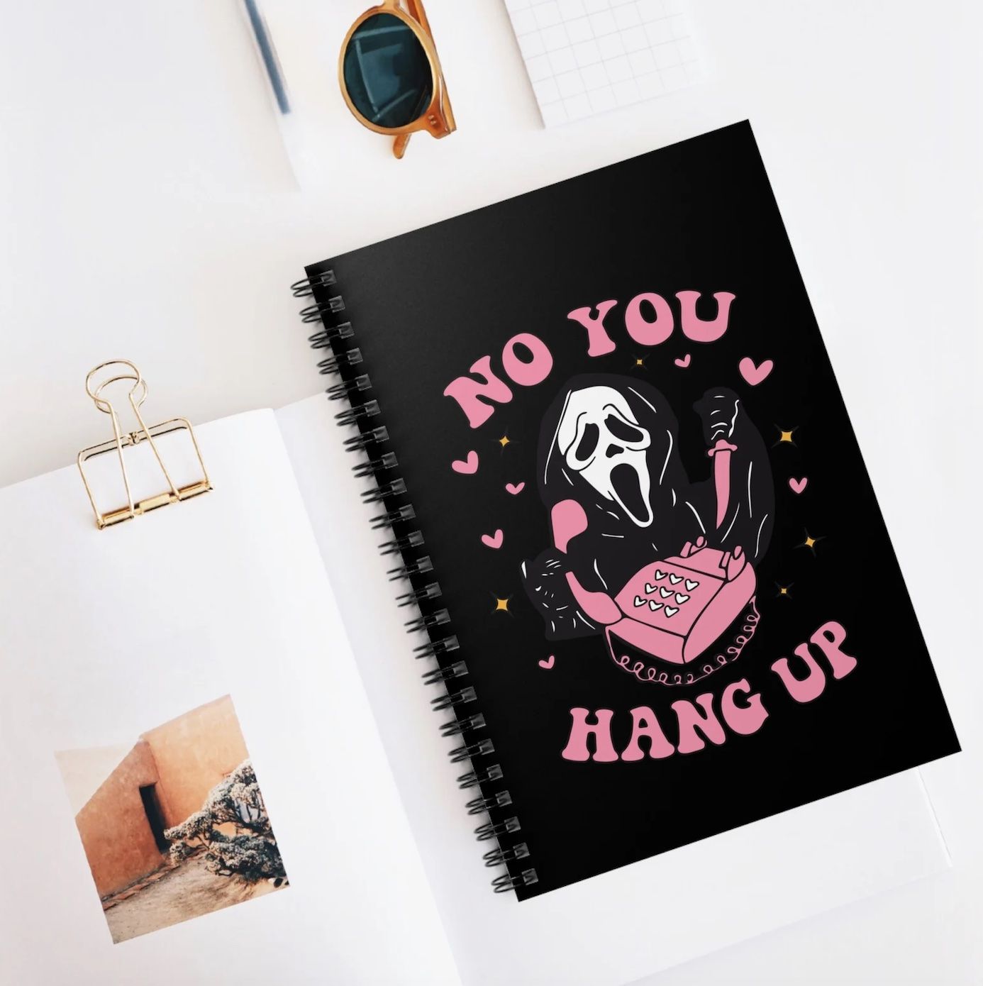 Black spiral notebook with the scream mask, telephone, and the words 