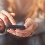 a photo of someone scrolling through their phone, just their hands in focus
