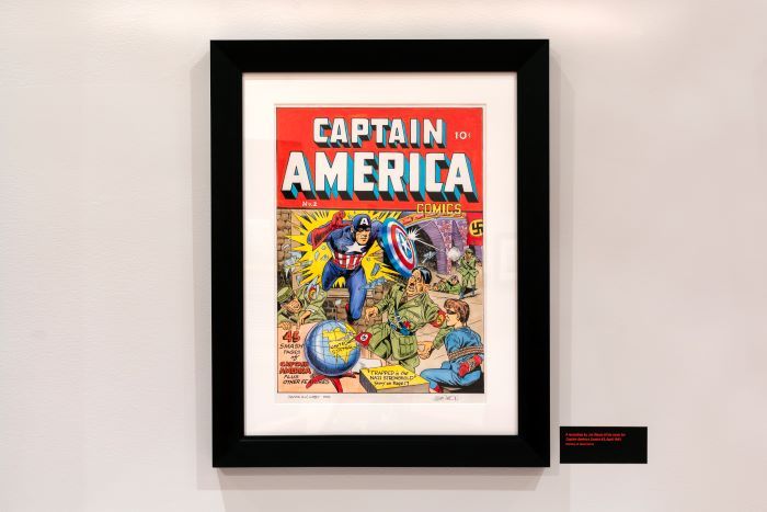a photo of a a framed Captain-America book cover displayed on a wall