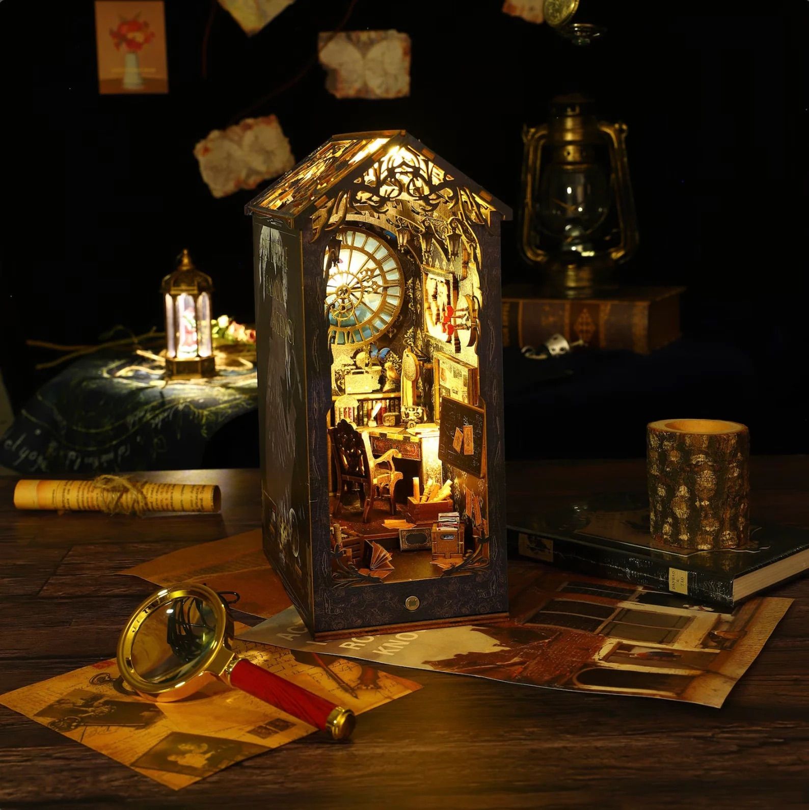 DIY Book Nook Kit on a desk with papers, candles, books, and a magnifying glass. 