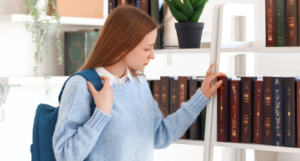 a photo of a young woman taking a book off a bookshelf