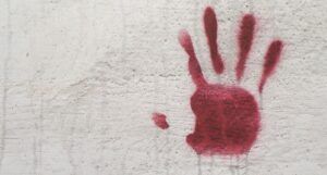 Image of a red handprint on a cement wall