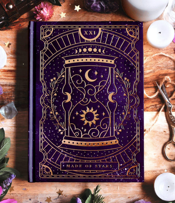 Purple notebook with a celestial theme including hourglass image and the words 'made of stars' on the bottom.