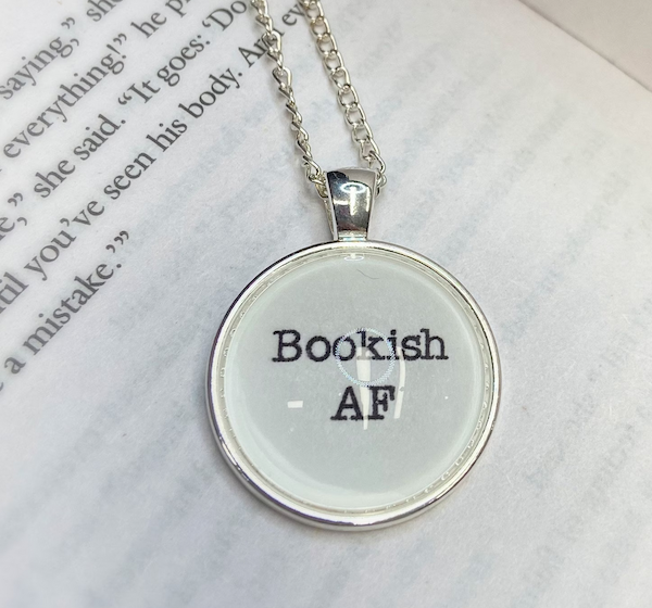a white round pendant with black lettering that says "bookish AF"