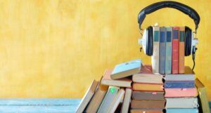 a stack of books with a pair of over-the-ear headphones over them