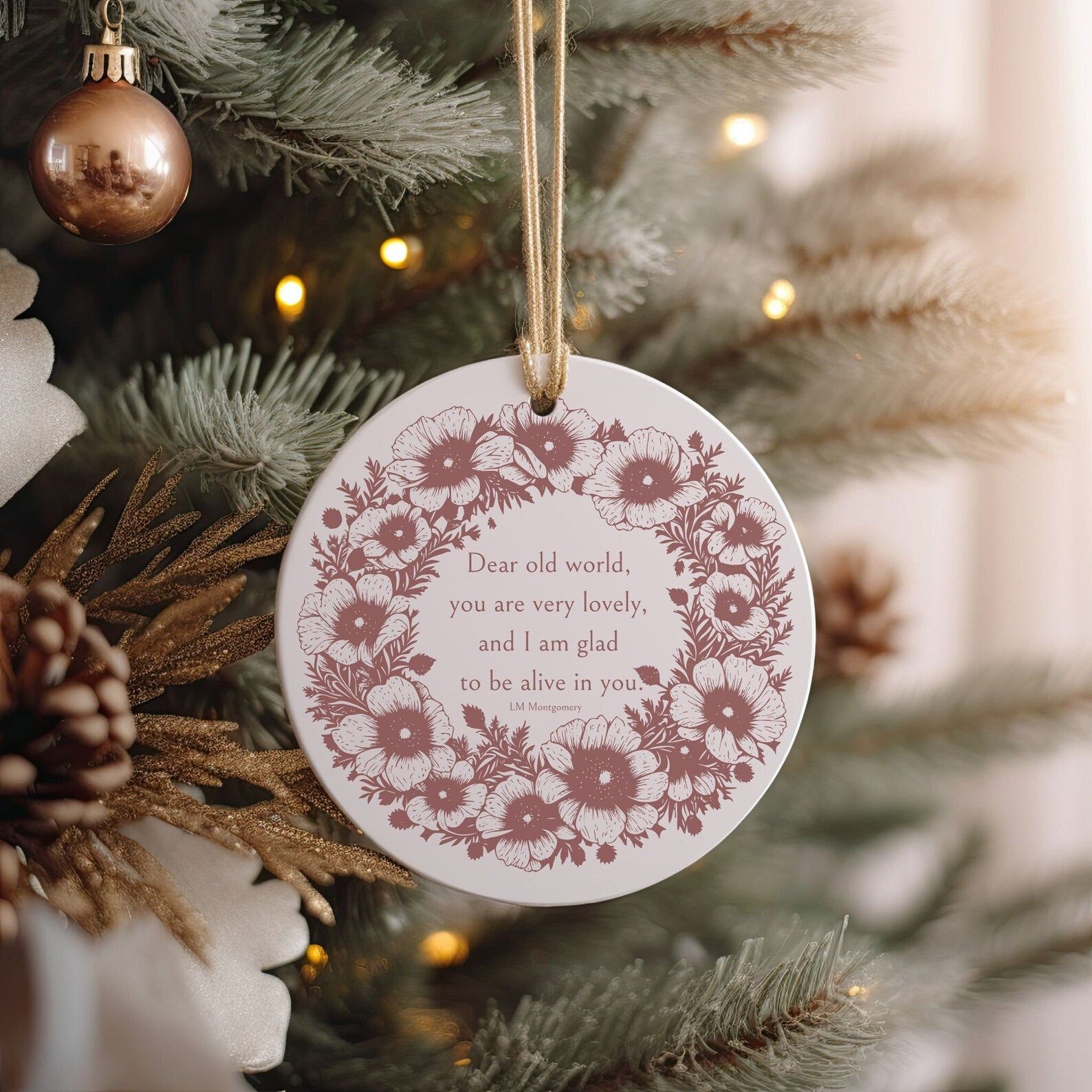 a round ceramic ornament with a flower border and the quote "Dear old world, you are very lovely, and I am glad to be alive in you."