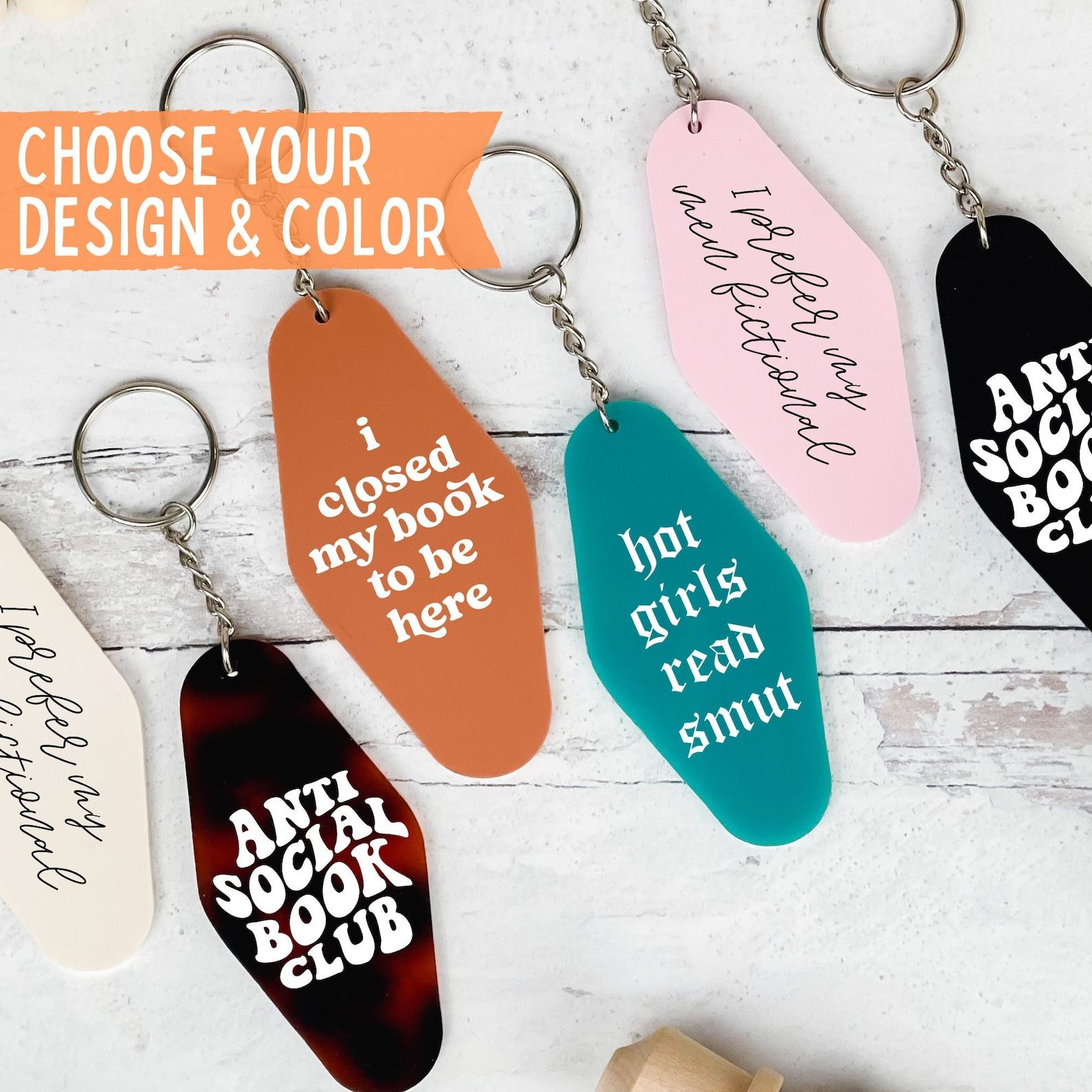 A set of various colored motel keychains with the words "I closed my book to be here" and "hot girls read smut"
