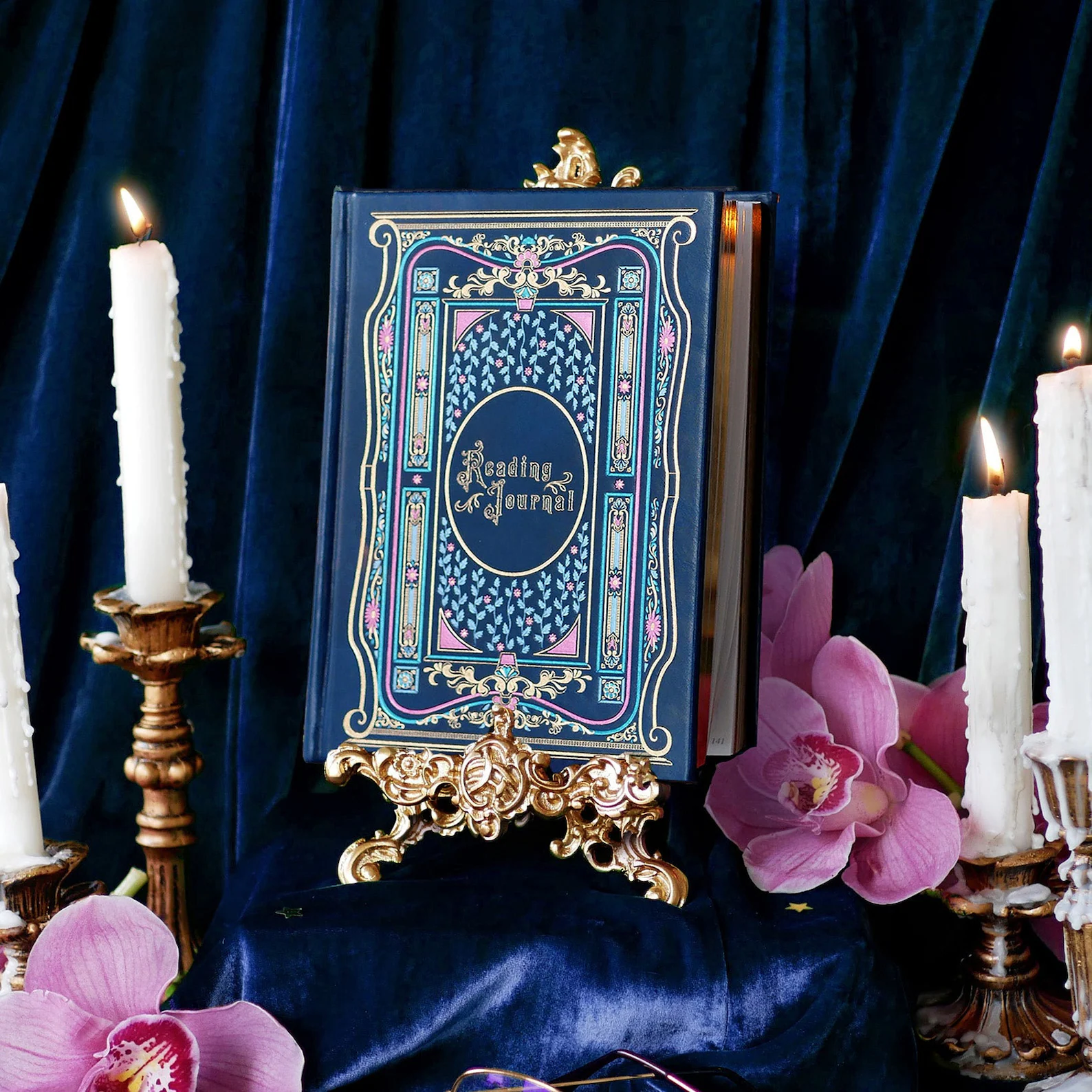 image of a deep blue reading journal surrounded by candles. 