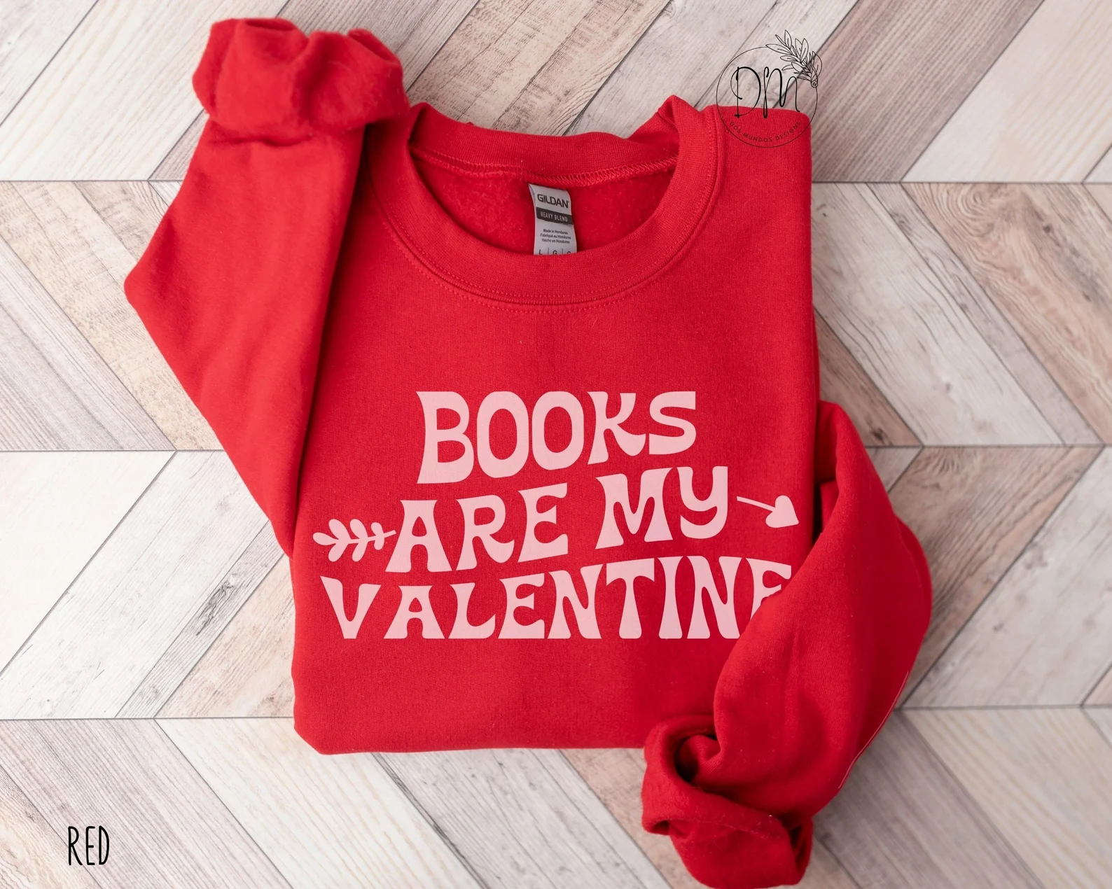 Image of a red sweatshirt with the words "books are my valentine" in pink. 