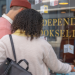 a photo of a couple looking into a bookstore window