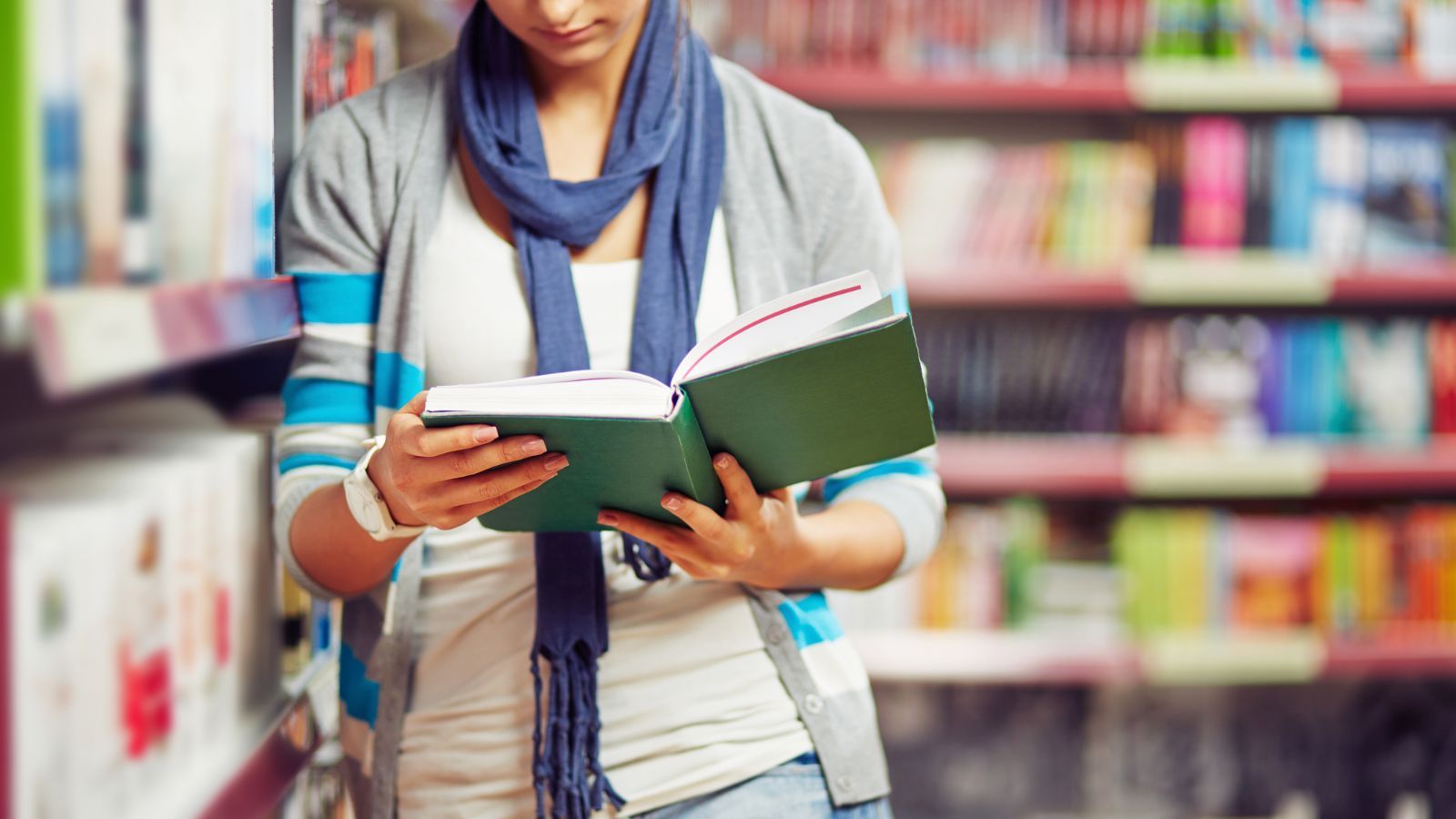 Image of a person inside the library with an open book. 