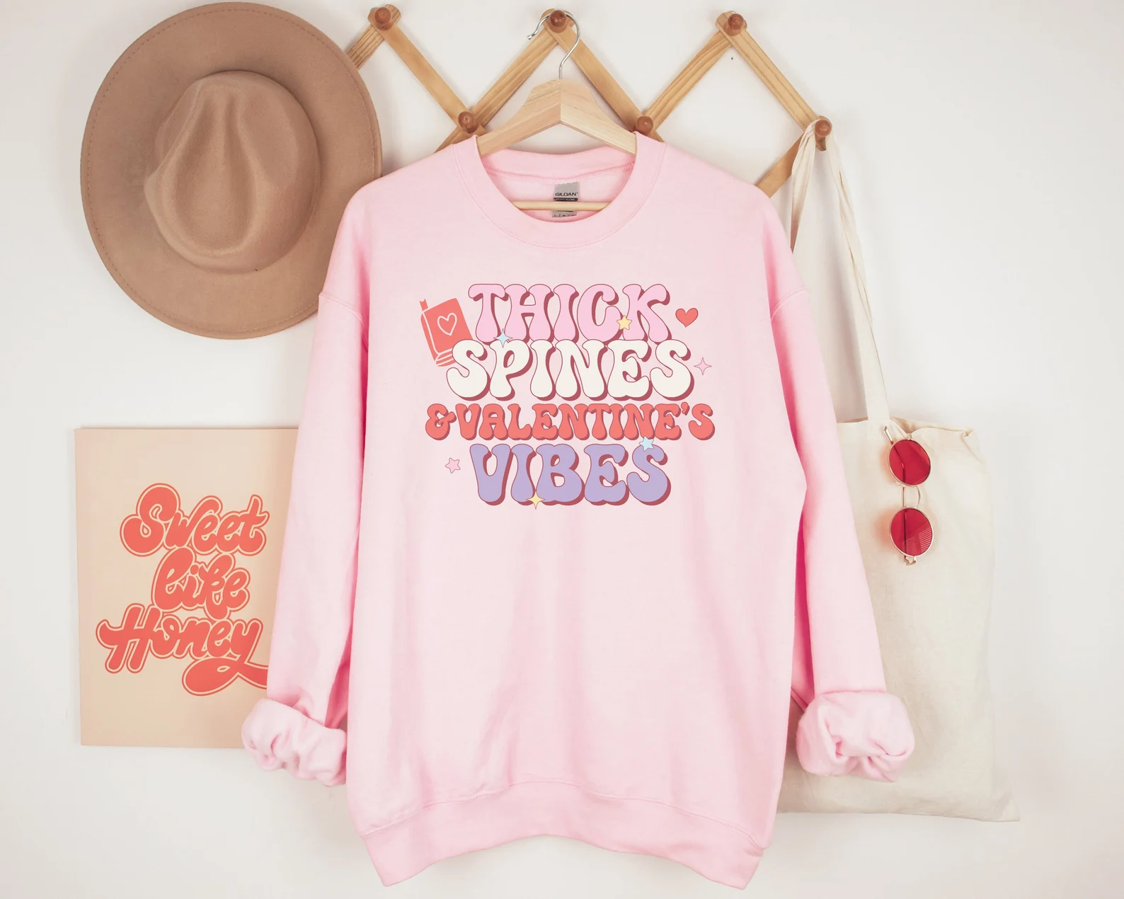 image of a pink sweatshirt with the text "thick spines and valentine's vibes."